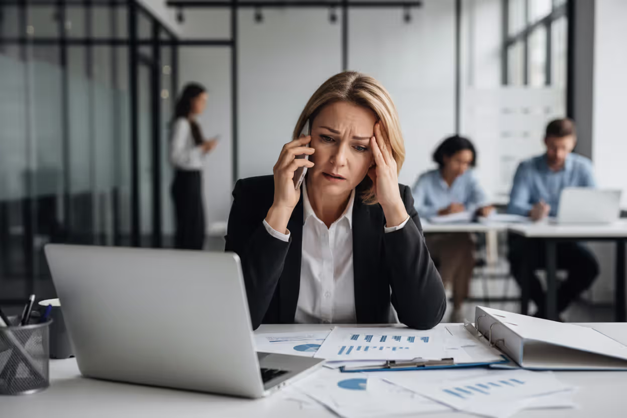 Stressed woman at work handling an urgent call about an elderly parent