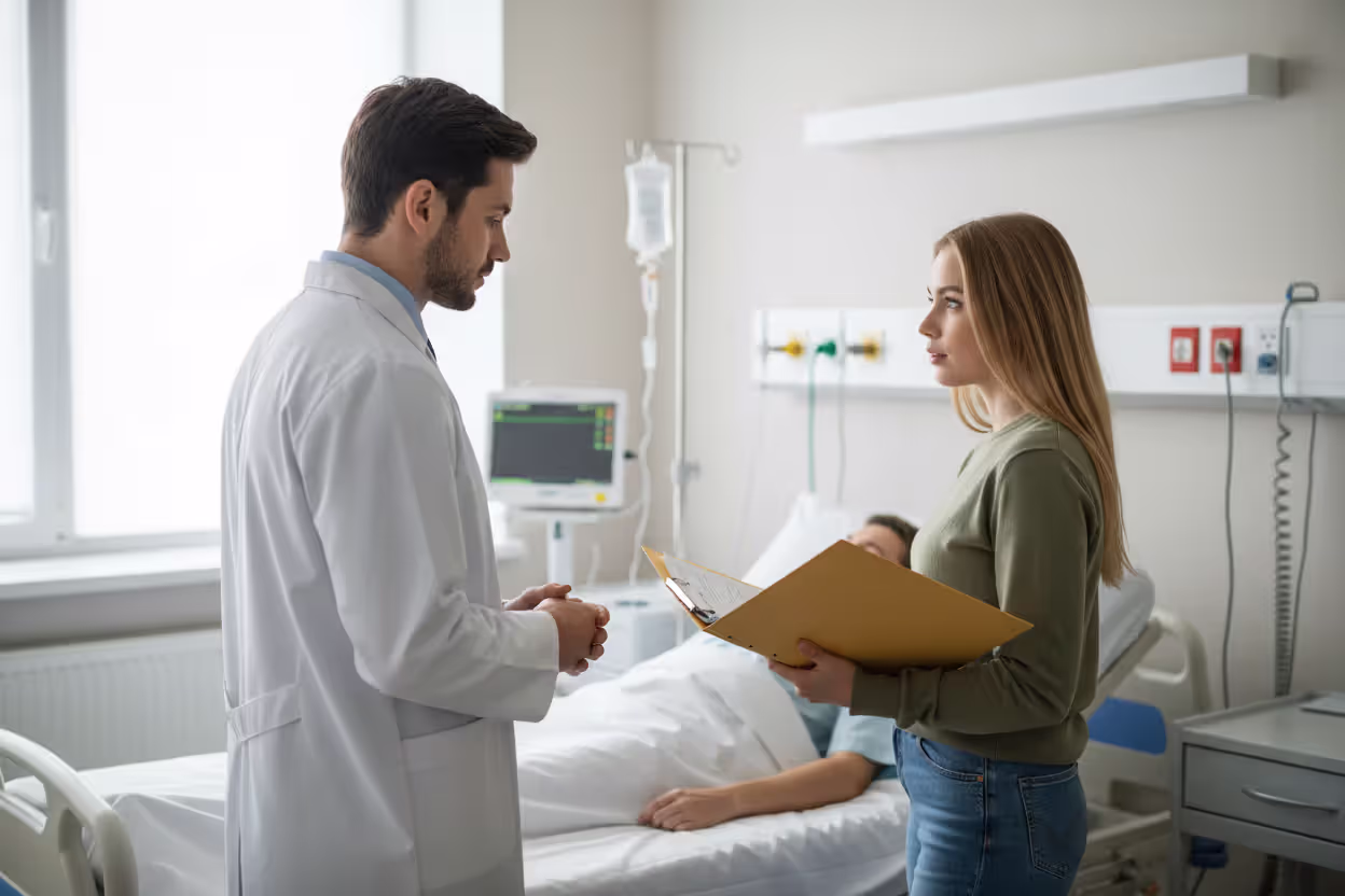 Healthcare professional discussing medical directives with a patient visitor holding documents in a hospital room